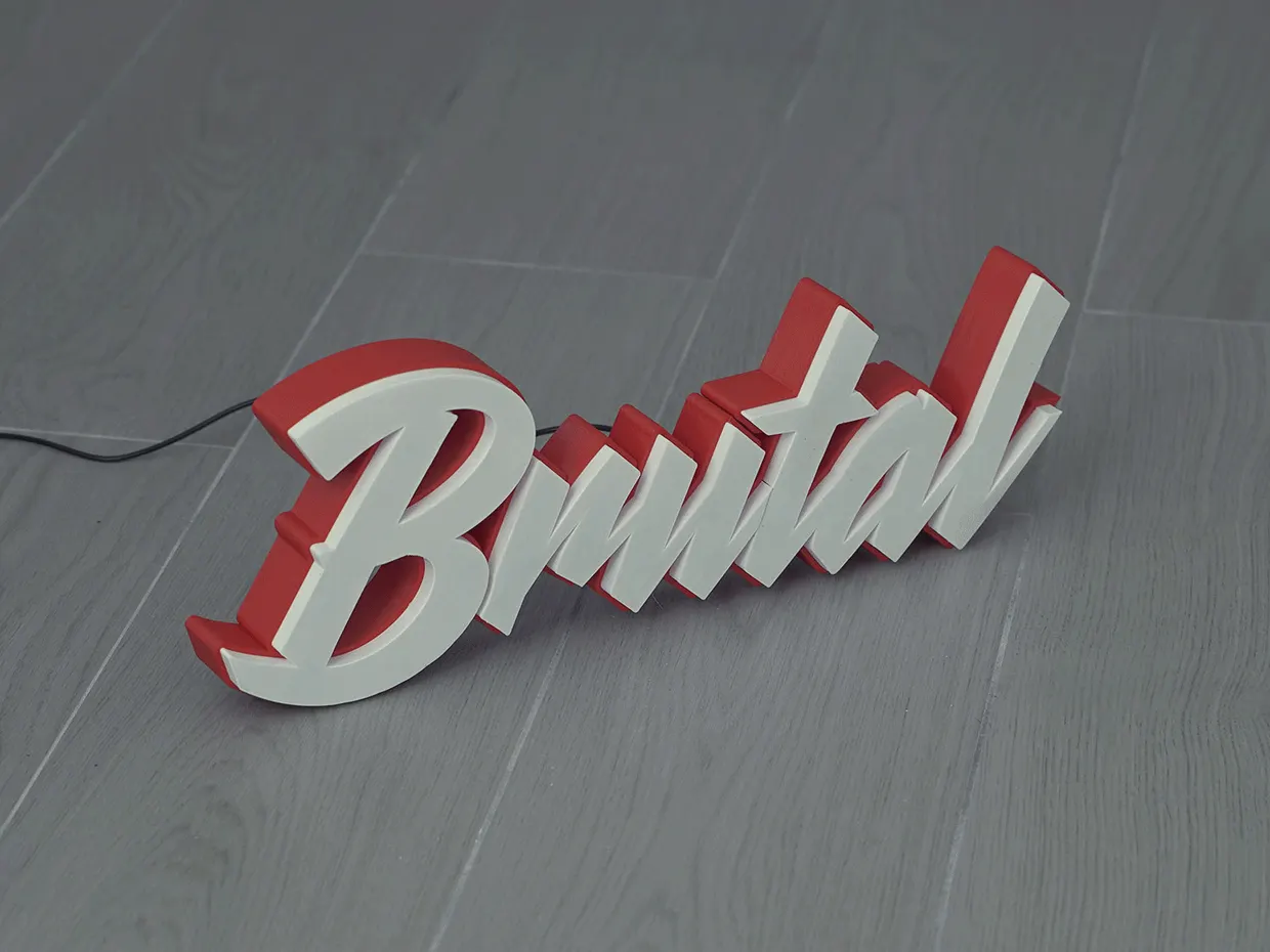 A 3D letter sign spelling 'Brutal' in white script letters with red sides and a power cable on a wood-look floor, shown unlit and then lit with a cool-white and a warm-white glow